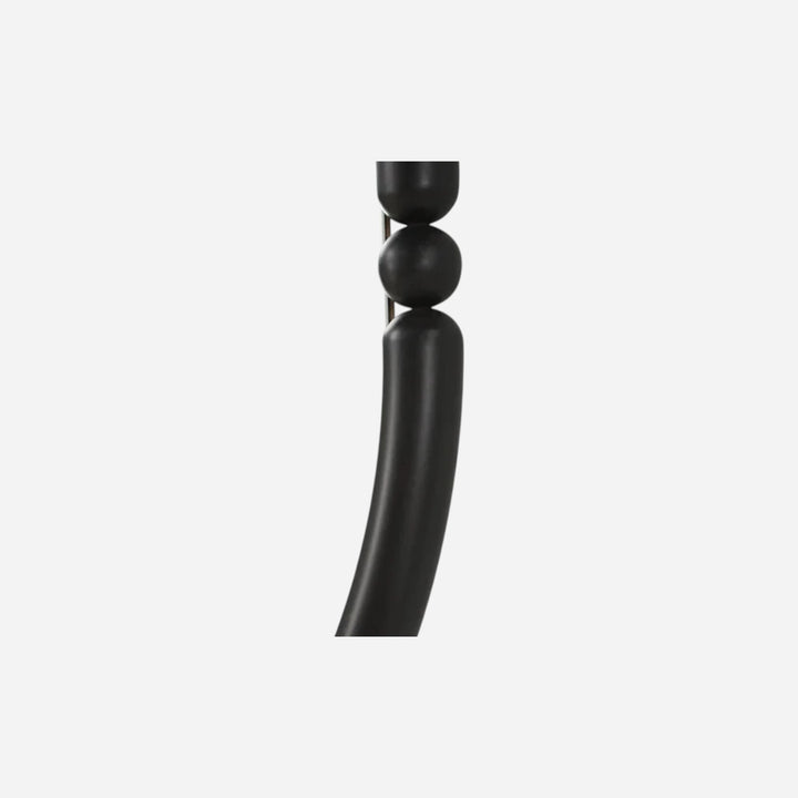 Gros plan sur le cadre en fer thermolaqué noir mat du miroir ovale Maison Olive avec détails de perles sculpturales.
