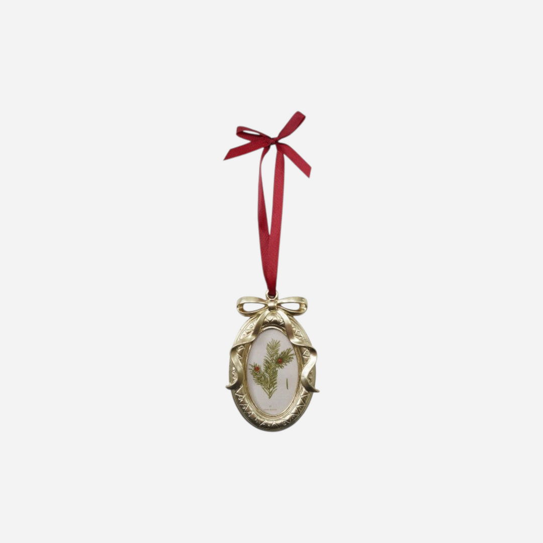 Ornement de Noël Maison Olive en forme de cadre ovale doré avec illustration botanique et ruban de satin rouge