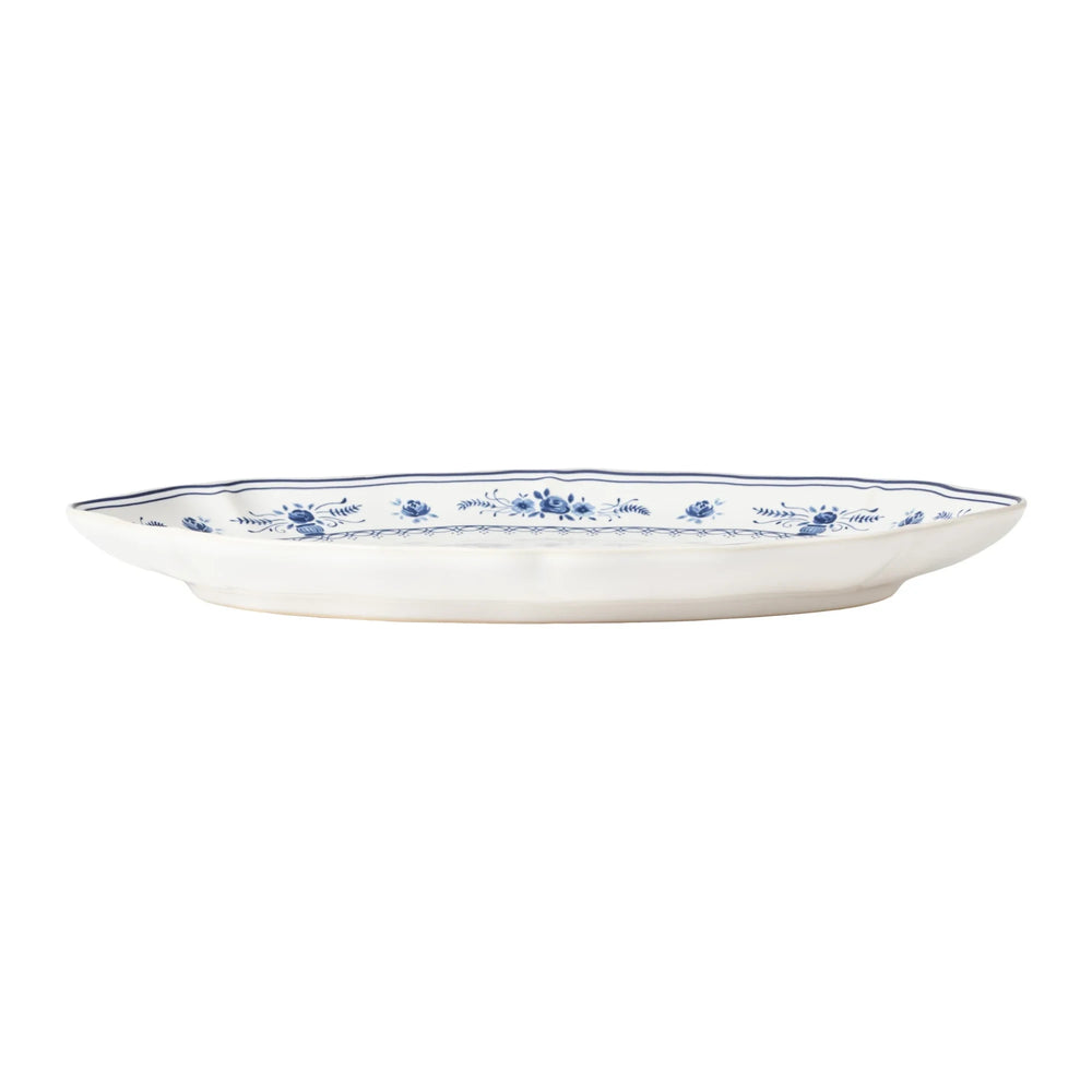 Grand plat de service ovale en céramique Maison Olive avec motifs floraux bleus classiques et bords ondulés.