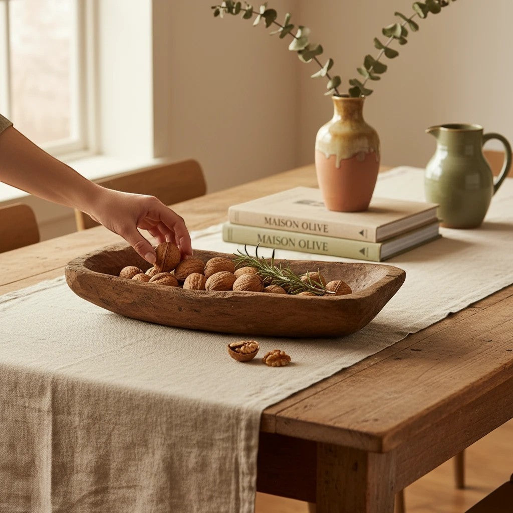 Plateau décoratif Maison Olive en bois brut sculpté à la main, rempli de noix sur une table rustique.