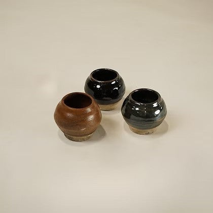Ensemble de trois petits pots en céramique artisanale Maison Olive aux finitions émaillées dans des tons terreux.