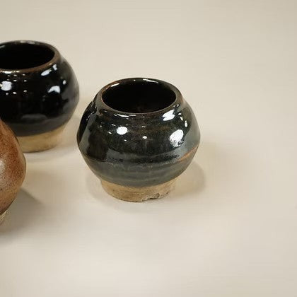 Ensemble de petits pots en céramique artisanale Maison Olive, finition émaillée sombre et base brute, style rustique.