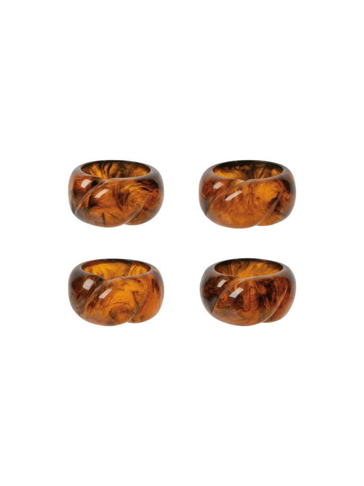 Ensemble de quatre ronds de serviette Maison Olive en résine effet ambre aux nuances dorées et translucides