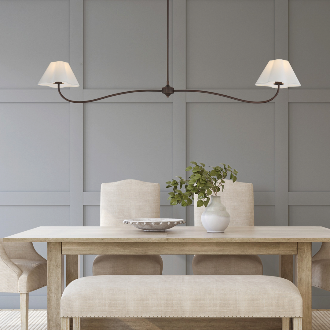 Suspension Maison Olive à deux bras avec abat-jours en tissu blanc cassé au-dessus d'une table de salle à manger