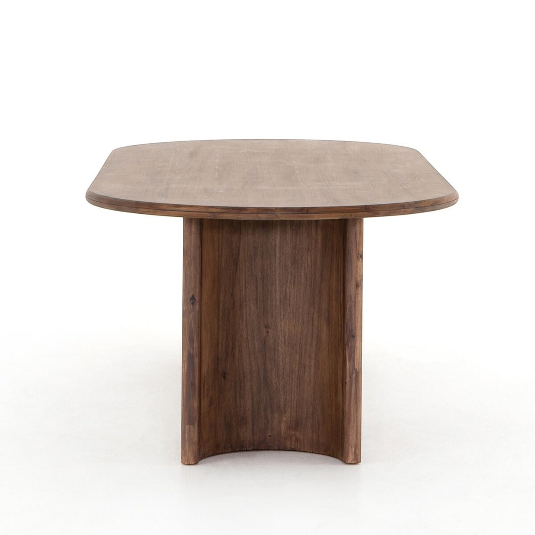 Table à manger ovale en bois d'acacia noir vieilli de Maison Olive, design sculptural avec piétement cylindrique.