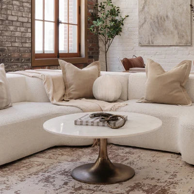 Table basse ronde Maison Olive avec plateau en marbre blanc et pied central tulipe en métal finition bronze vieilli