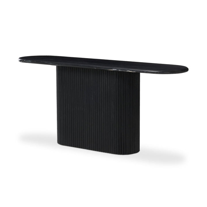 Maison Olive Table basse ovale en marbre noir veiné avec pied cylindrique cannelé noir.