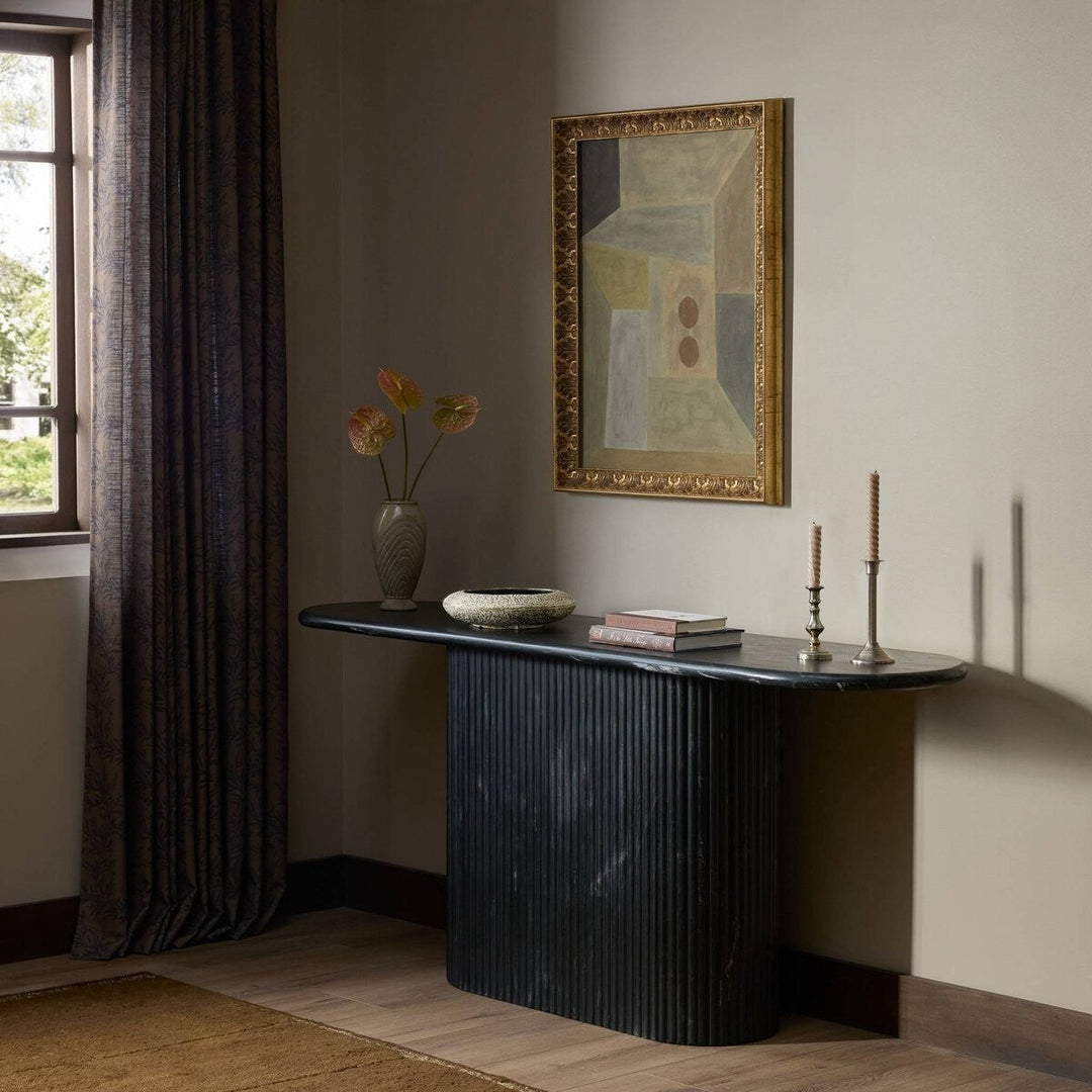Maison Olive table basse ovale en marbre noir veiné avec pied cannelé, design sculptural et élégant.