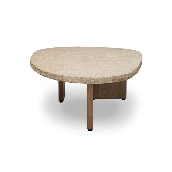 Table basse Maison Olive en travertin beige texturé aux formes organiques, avec pieds en bois clair. Style naturel et contemporain.