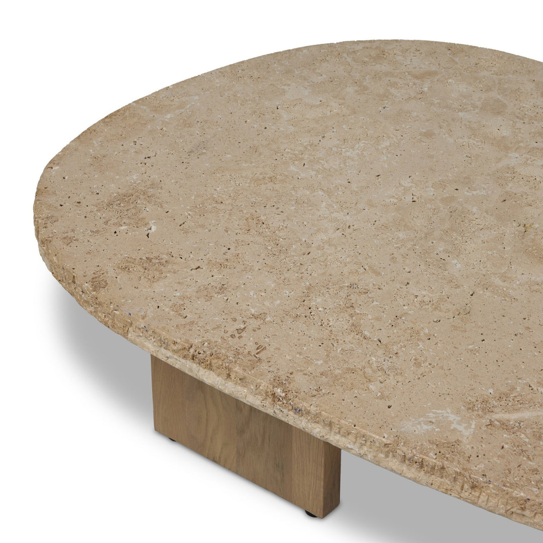 Maison Olive table basse ovale en travertin beige texturé avec pied en bois clair, style naturel et contemporain.