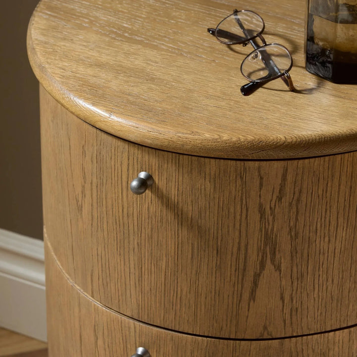 Maison Olive table de chevet ronde en bois de chêne massif avec tiroir et poignée en métal noir. Style scandinave.