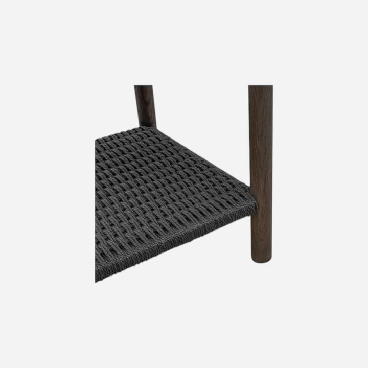 Détail de l'étagère en corde tressée noire et pieds en bois foncé de la table de chevet Maison Olive