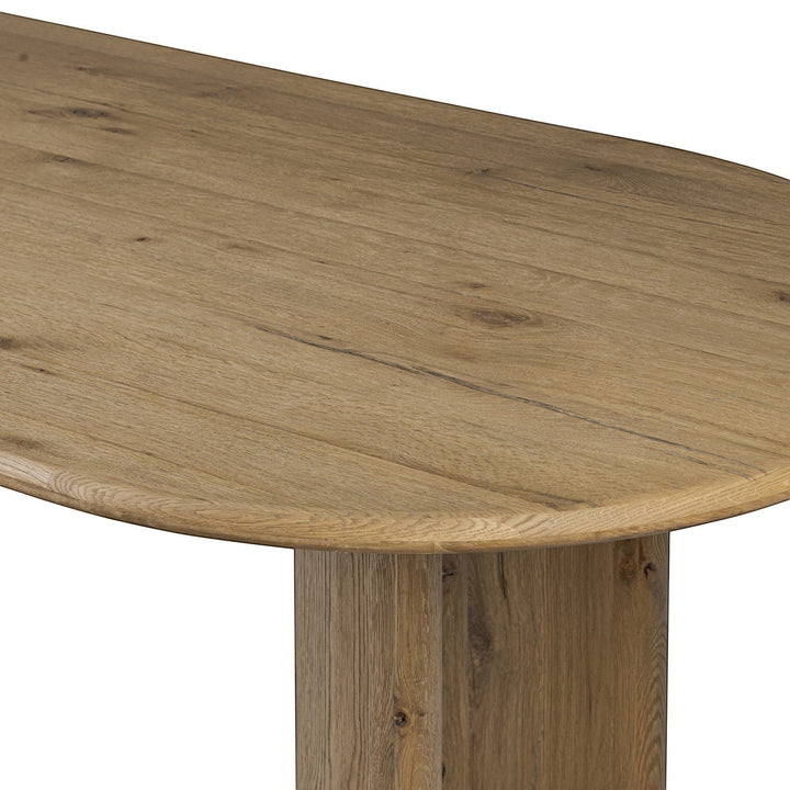 Table à manger ovale en bois d'acacia naturel vieilli, piétement cylindrique imposant, design sculptural par Maison Olive.