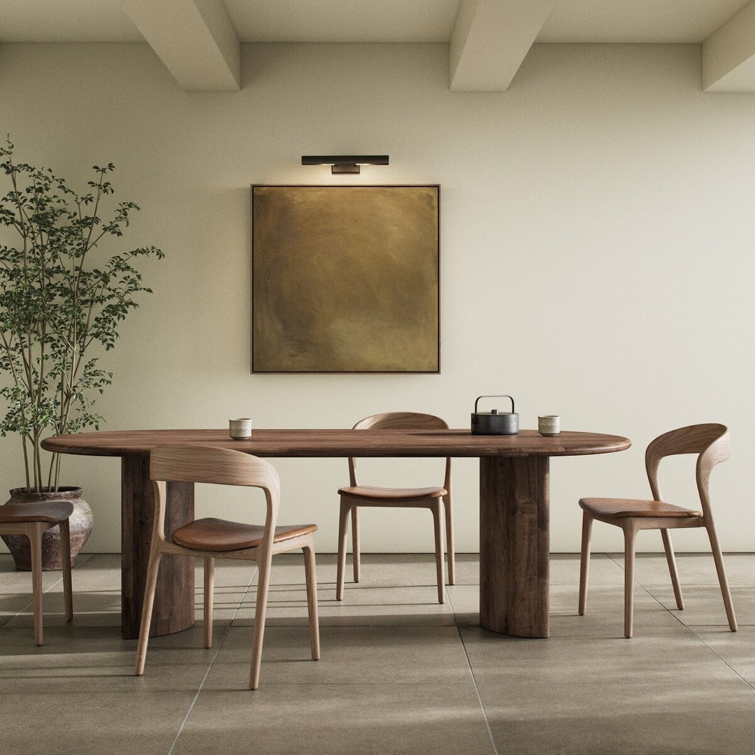 Table à manger ovale en bois d'acacia noir vieilli Maison Olive, design sculptural, piétement cylindrique, pour salle à manger.