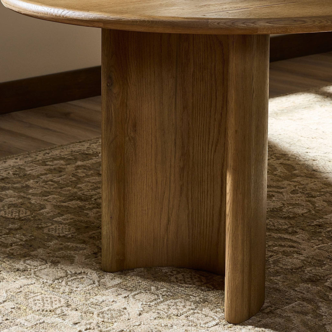 Table à manger ovale en bois d'acacia noir vieilli de Maison Olive, design sculptural avec piétement cylindrique.