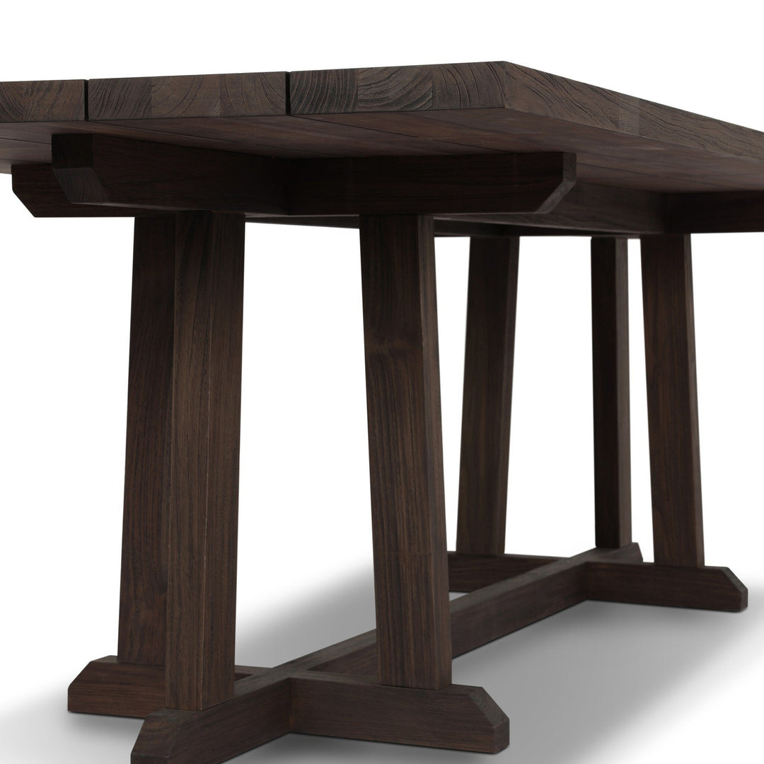 Table à manger Maison Olive en bois massif foncé, plateau à lattes, pieds croisés en H, style rustique moderne.