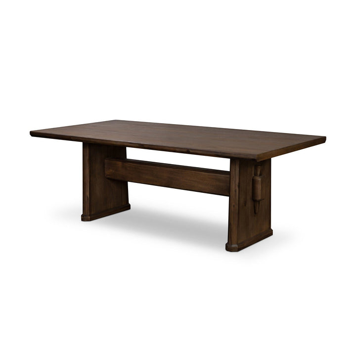 Maison Olive Table à manger rustique en bois massif avec piètement sculpté, finition naturelle foncée.