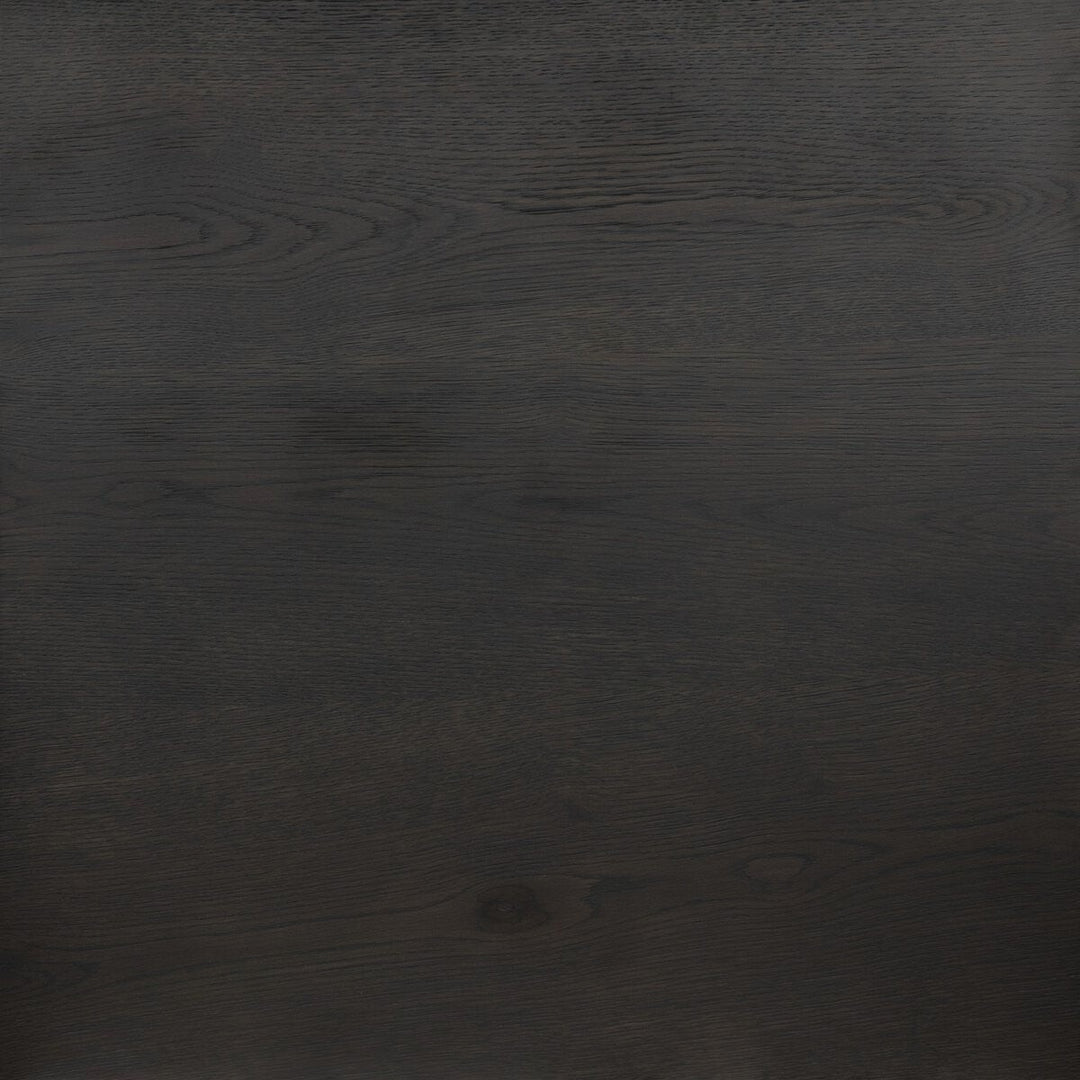 Table à manger ovale en bois de chêne noir Maison Olive avec grain subtil et piédestal central.