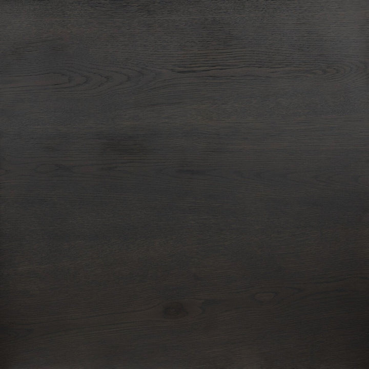 Table à manger ovale en bois de chêne noir Maison Olive avec grain subtil et piédestal central.