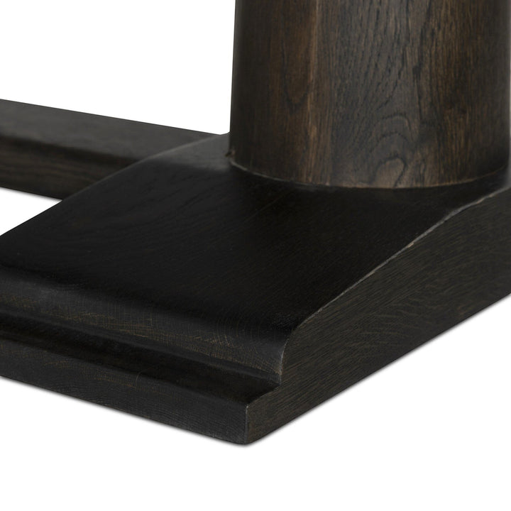 Table à manger ovale Maison Olive en bois de chêne noir, piédestal central, finition grain de bois subtil.