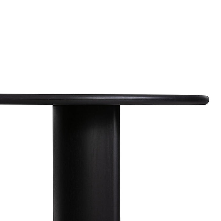 Table à manger ovale en bois noir Maison Olive avec piétement cylindrique massif. Design moderne et épuré.