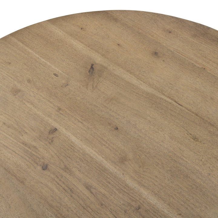 Maison Olive Table ronde en bois naturel avec plateau circulaire et finition légèrement vieillie, grain de bois visible.
