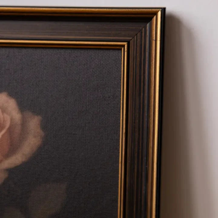 Tableau Maison Olive représentant une rose sur fond sombre avec un cadre élégant aux finitions noires et dorées.