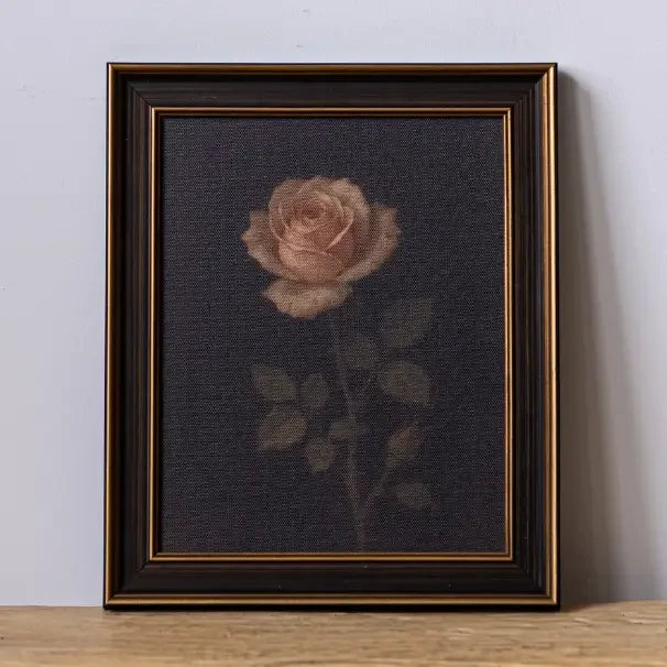 Tableau Maison Olive représentant une rose poudrée sur fond sombre dans un cadre élégant noir et doré
