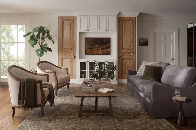 Tapis Junie Lagoon et Natural de Maison Olive dans un salon élégant avec fauteuils et canapé gris