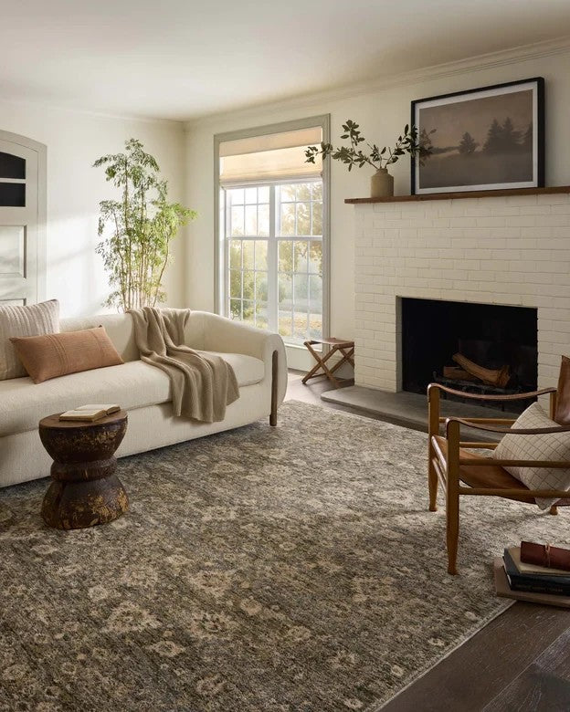 Tapis Junie Maison Olive aux motifs antiques dans des tons lagoon et naturel, installé dans un salon lumineux.