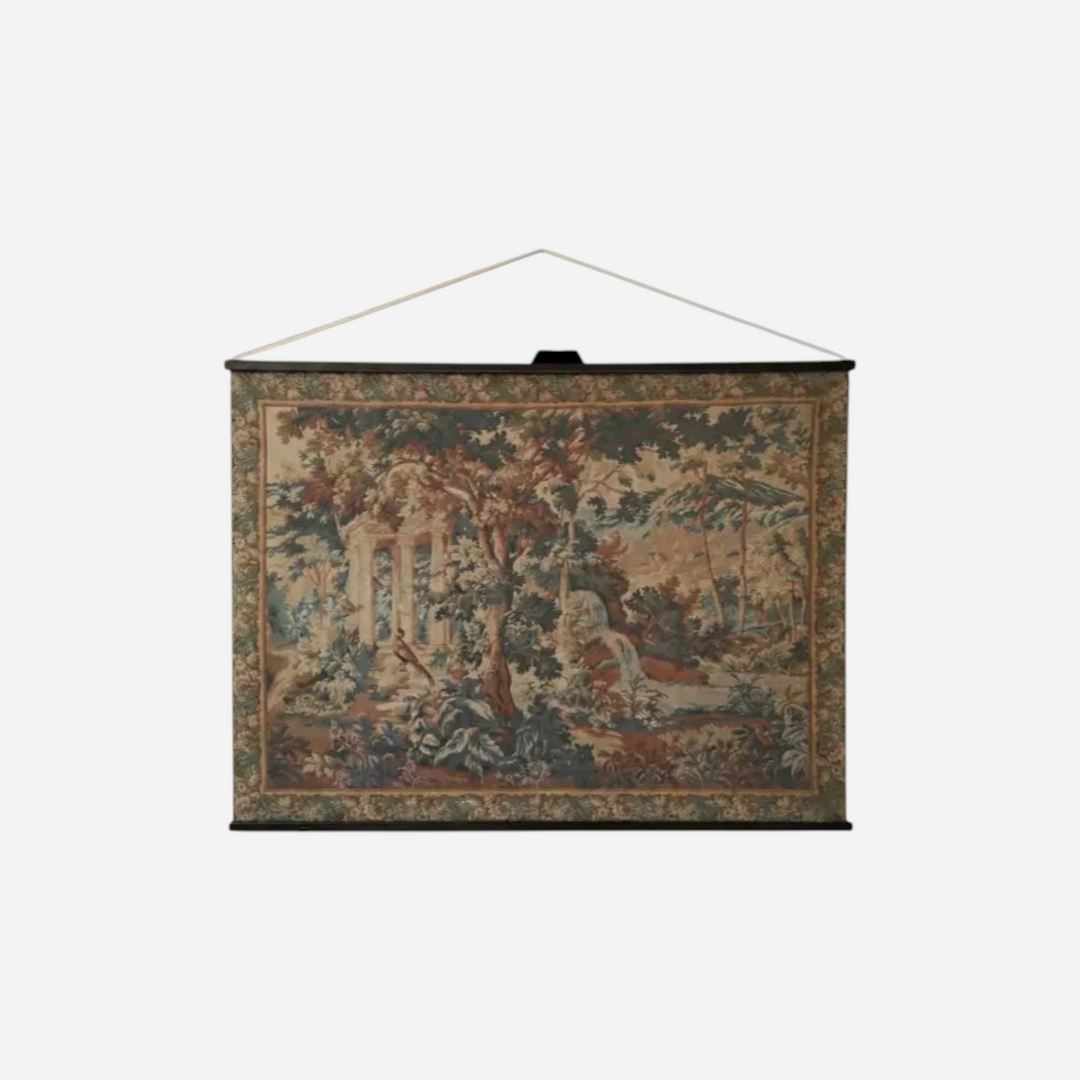 Tapisserie murale Maison Olive représentant une scène forestière avec ruines antiques, montée sur baguettes en bois.
