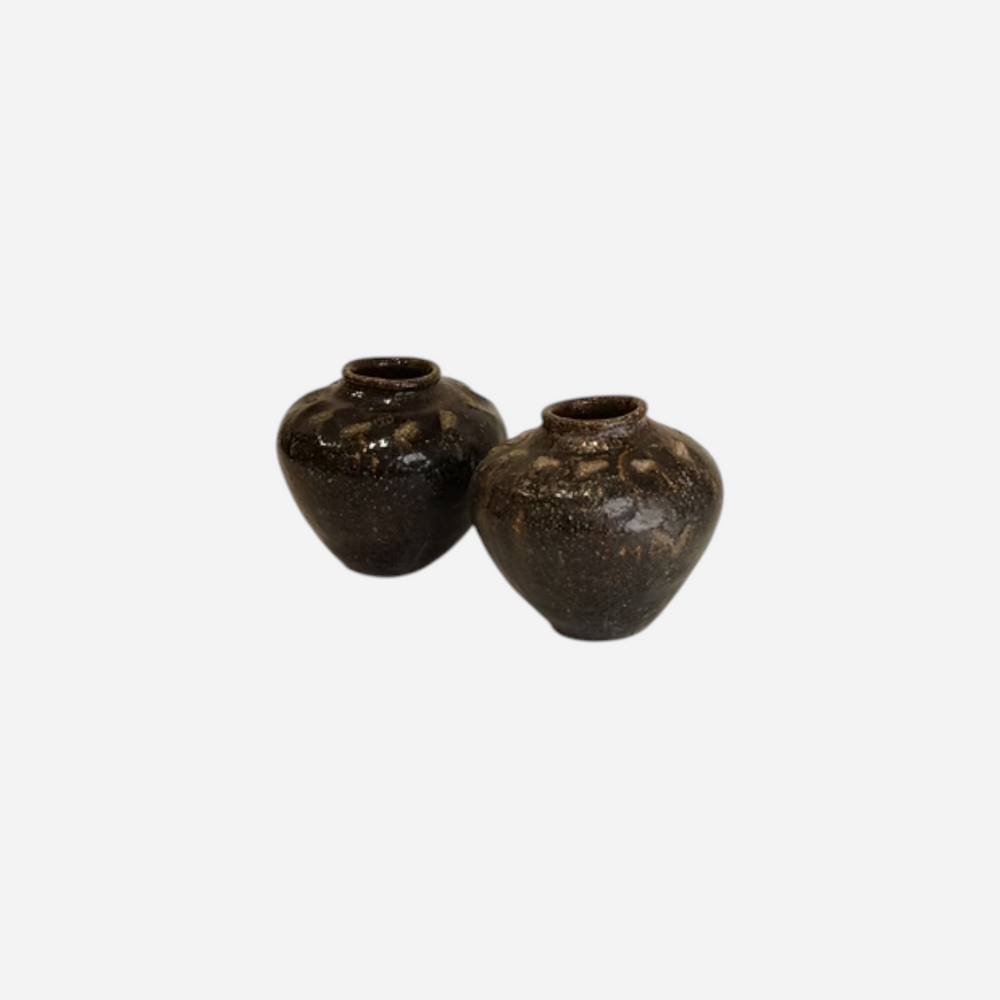 Deux vases Maison Olive en céramique sombre artisanale avec une finition texturée et une silhouette organique.