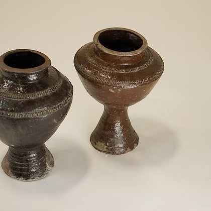 Ensemble de deux vases Maison Olive en terre cuite brune émaillée, design artisanal sur pied avec détails gravés.