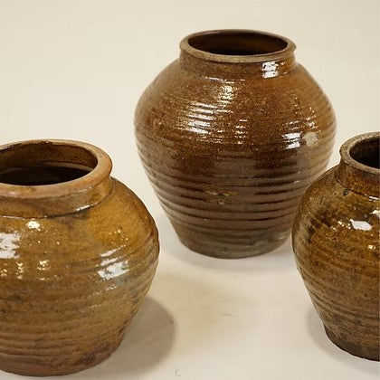 Ensemble de trois vases Maison Olive en terre cuite artisanale brune avec finition striée rustique.