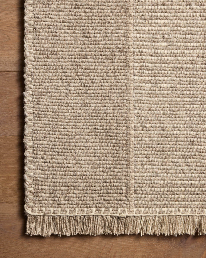 Détail de la texture et des franges du tapis Sigrid gris cendré et ivoire