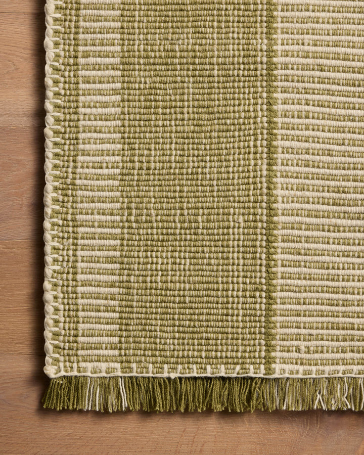 Détail de la texture et des franges du tapis Sigrid vert et ivoire