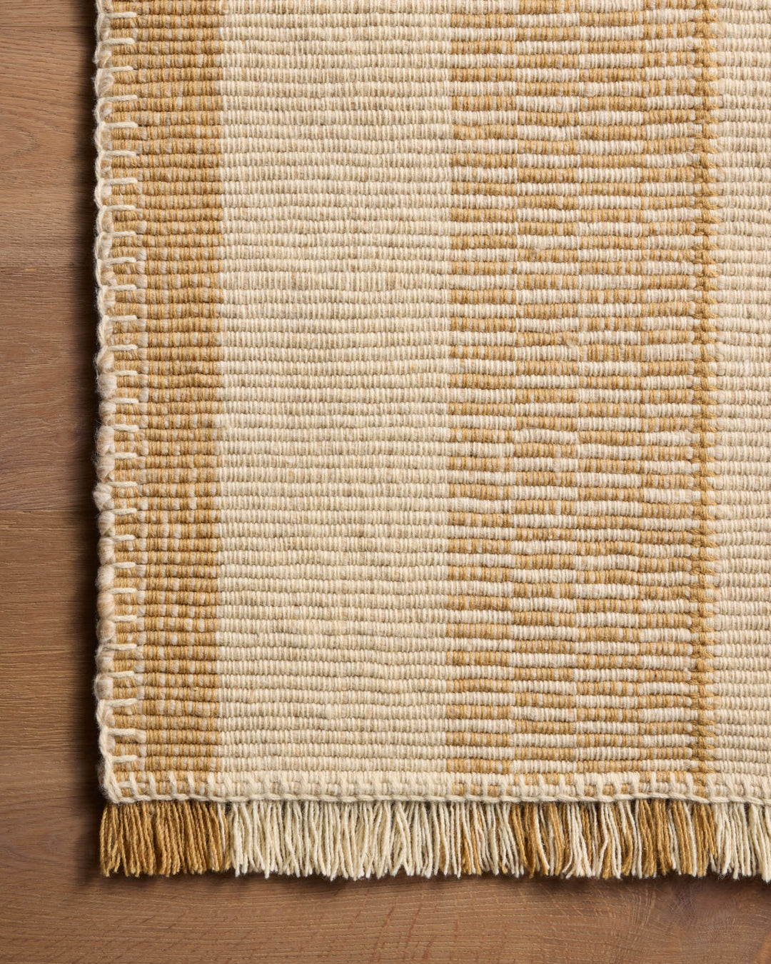Détail de la texture et des franges du tapis Sigrid jaune et ivoire
