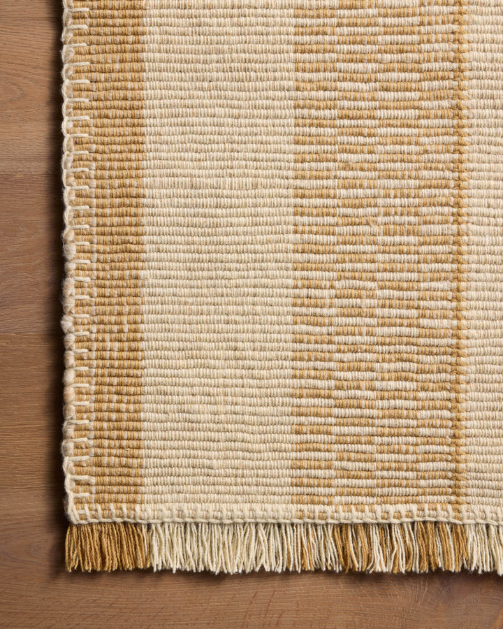 Détail de la texture et des franges du tapis Sigrid jaune et ivoire